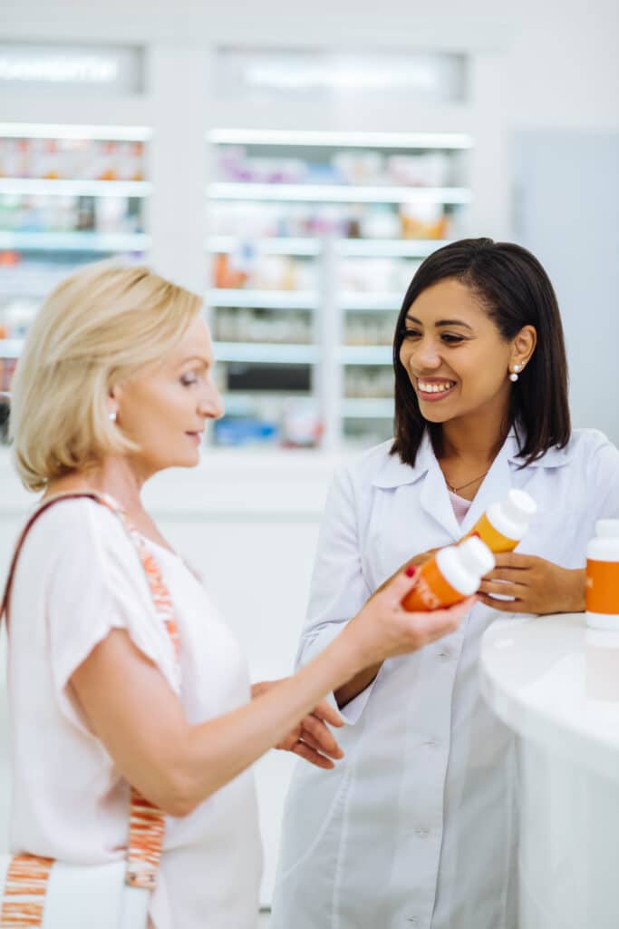Pharmacist assists customer with product choice.