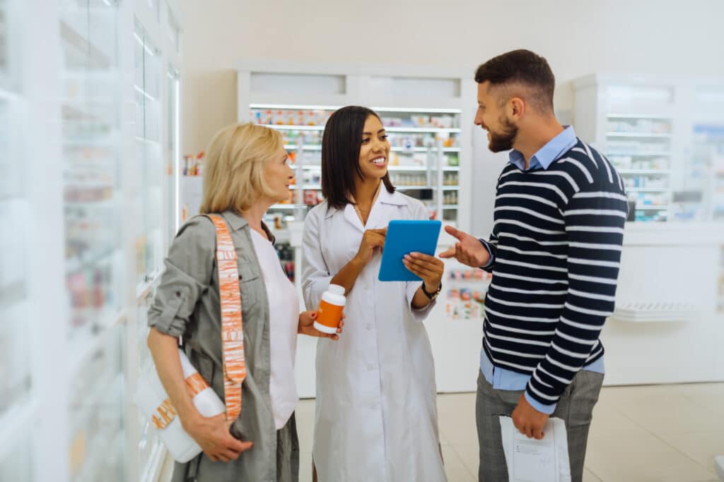 Pharmacist assisting customers in a pharmacy.