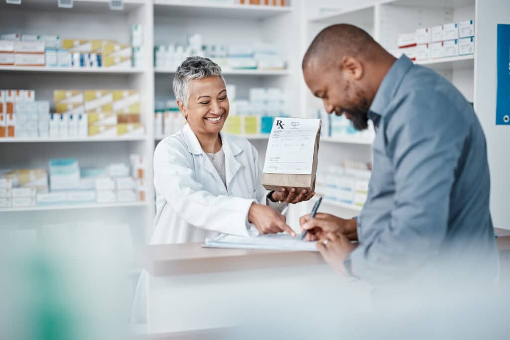 Pharmacist handing prescription to customer